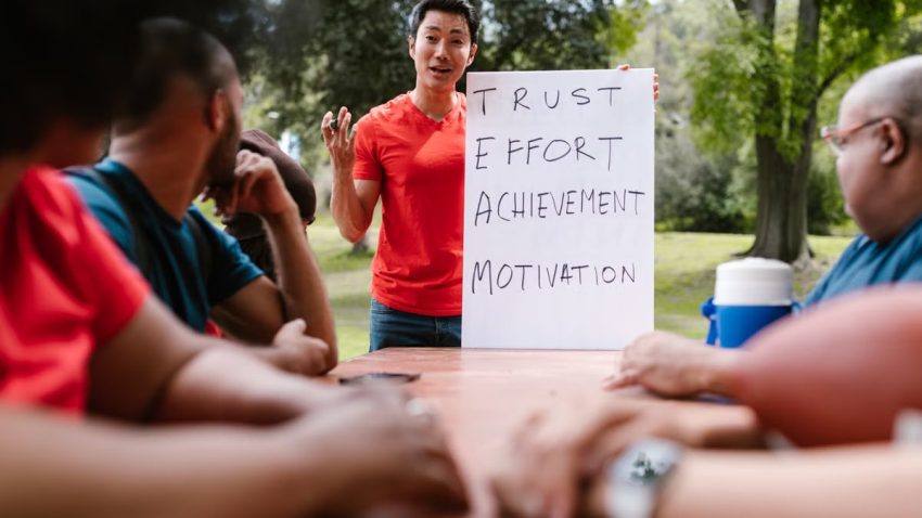 Diverse group engaged in outdoor team building, highlighting trust and effort.